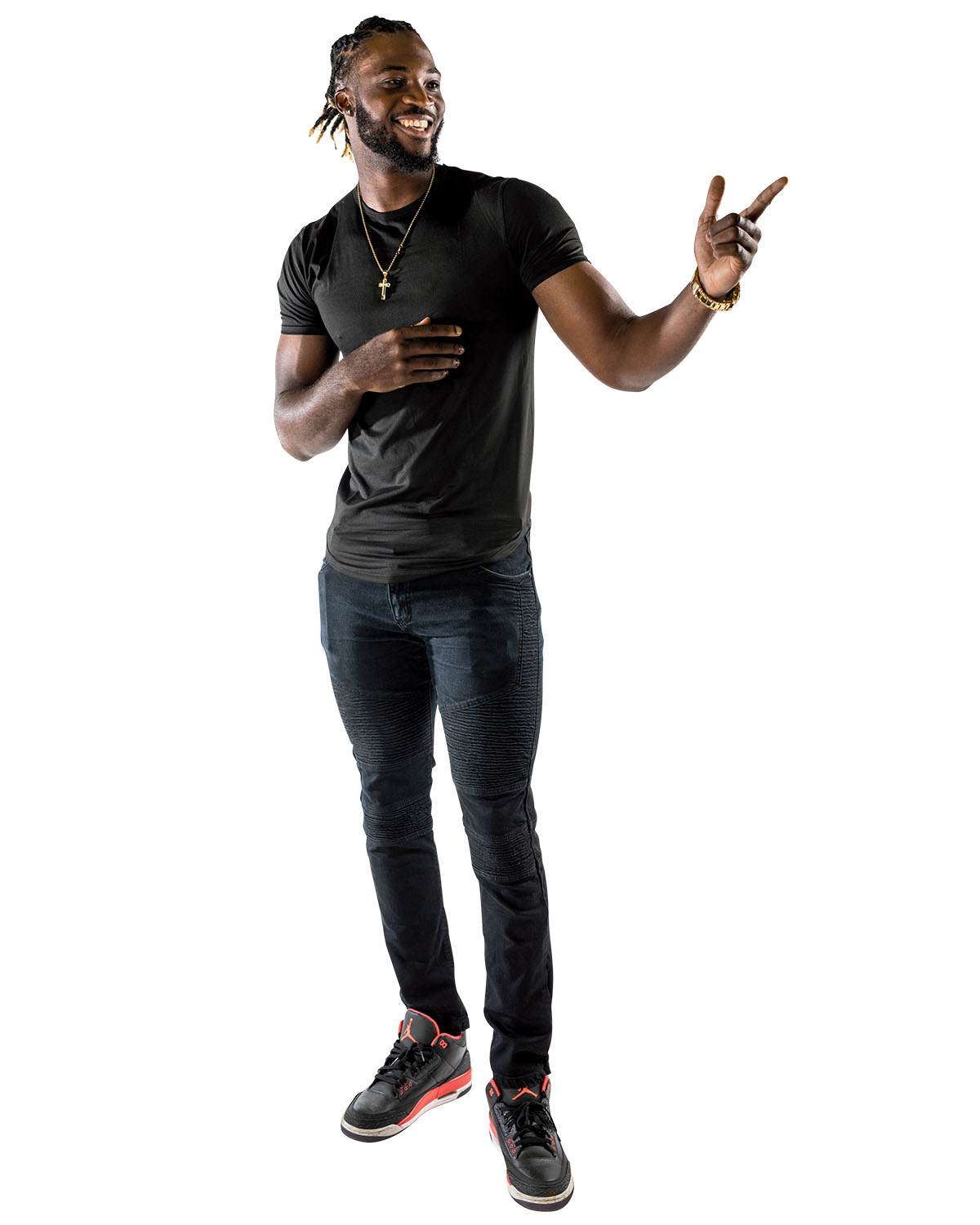 A tall man in a black shirt and jeans smiles as he looks to the side and points in the distance. A tall man in a black shirt and jeans smiles as he looks to the side and points in the distance.