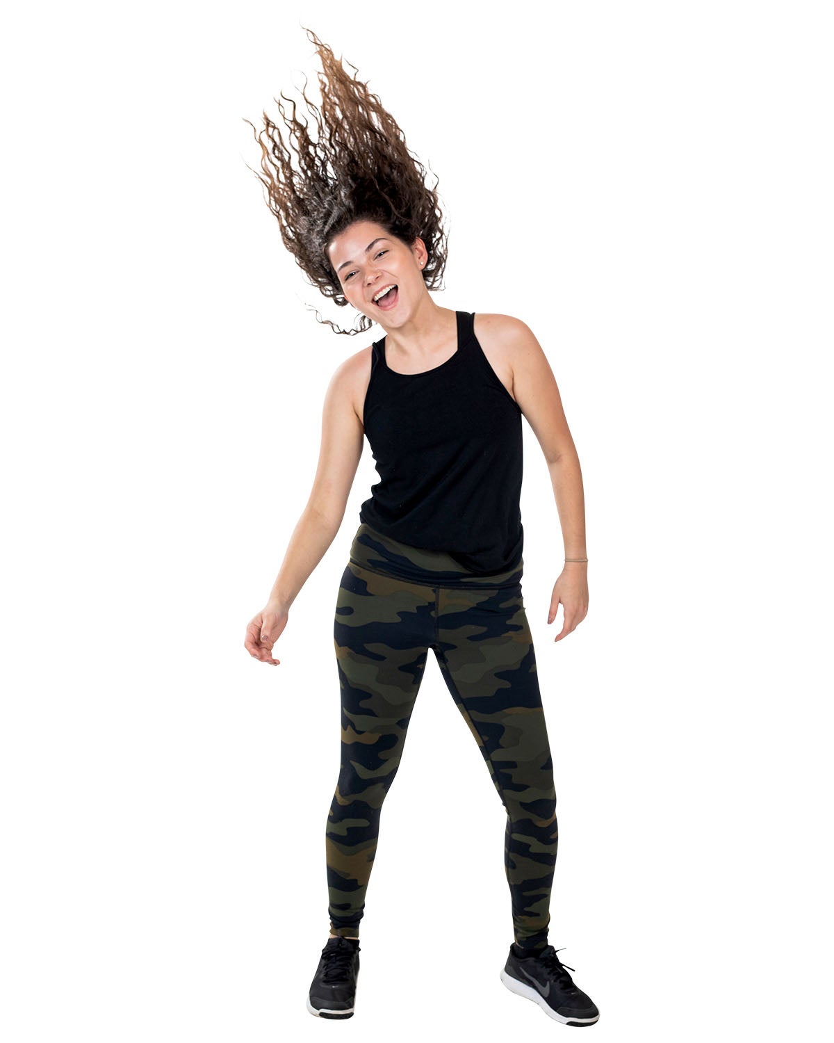 A woman in camp pants and a black tank top whips her wavy hair up as she smiles. A woman in camp pants and a black tank top whips her wavy hair up as she smiles.