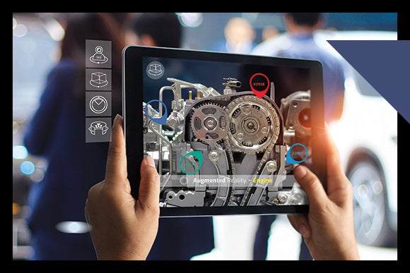pair of hands hold ipad with image of cogs and wheels