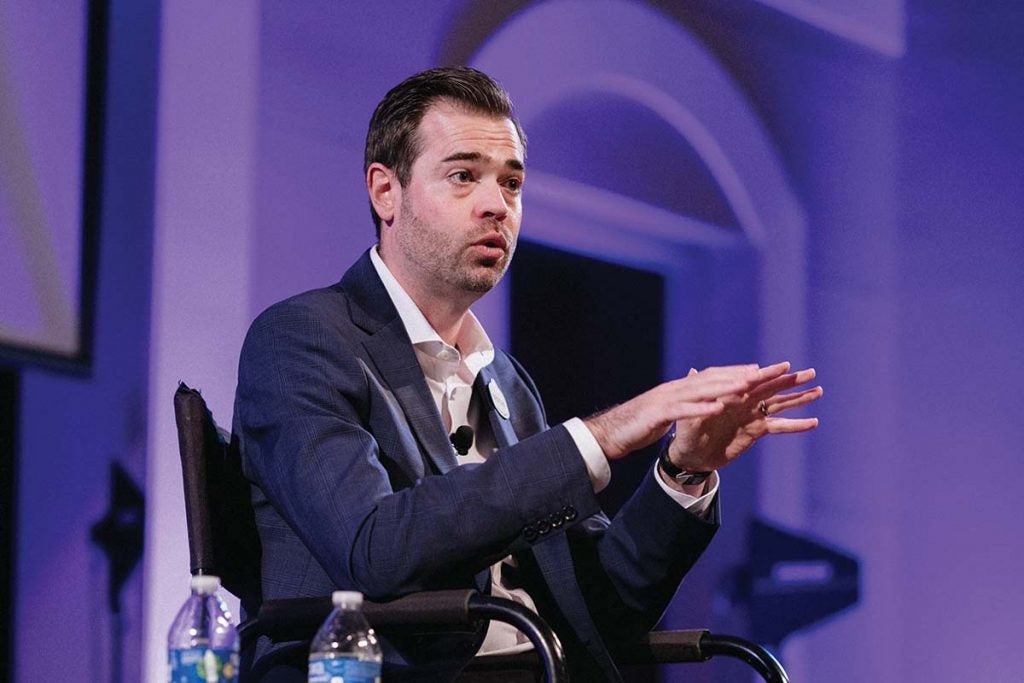 A man wearing a suit and speaking