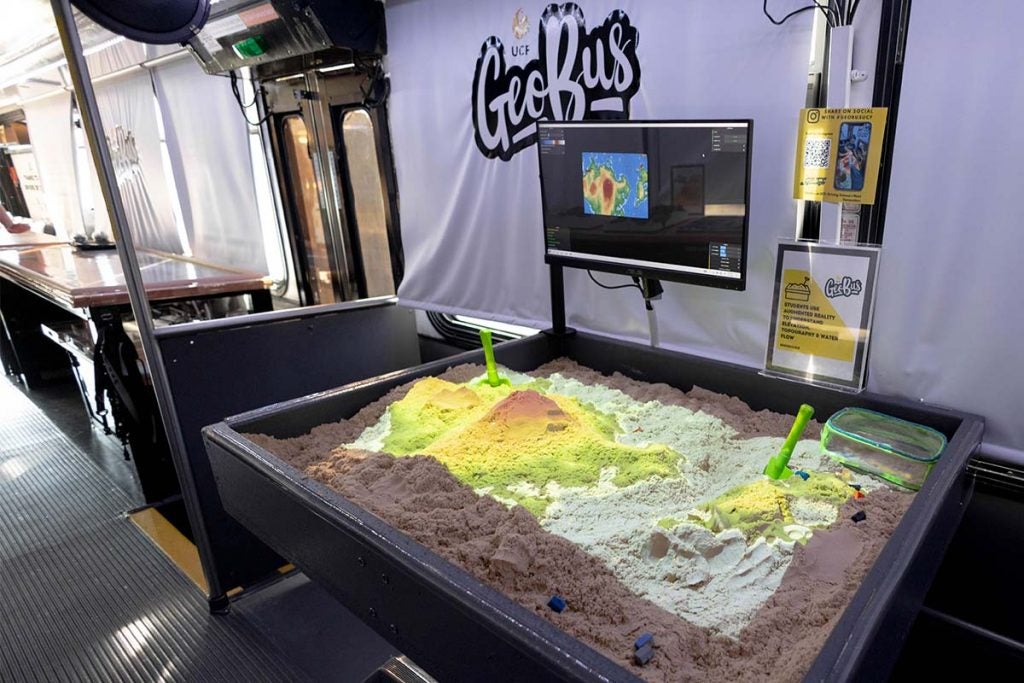 A diagonal view of a sandbox onboard the GeoBus that is filled with kinetic sand.