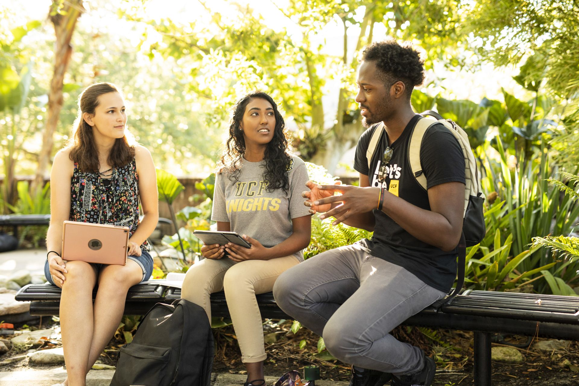 Three students socialize in the Meditation Garden.