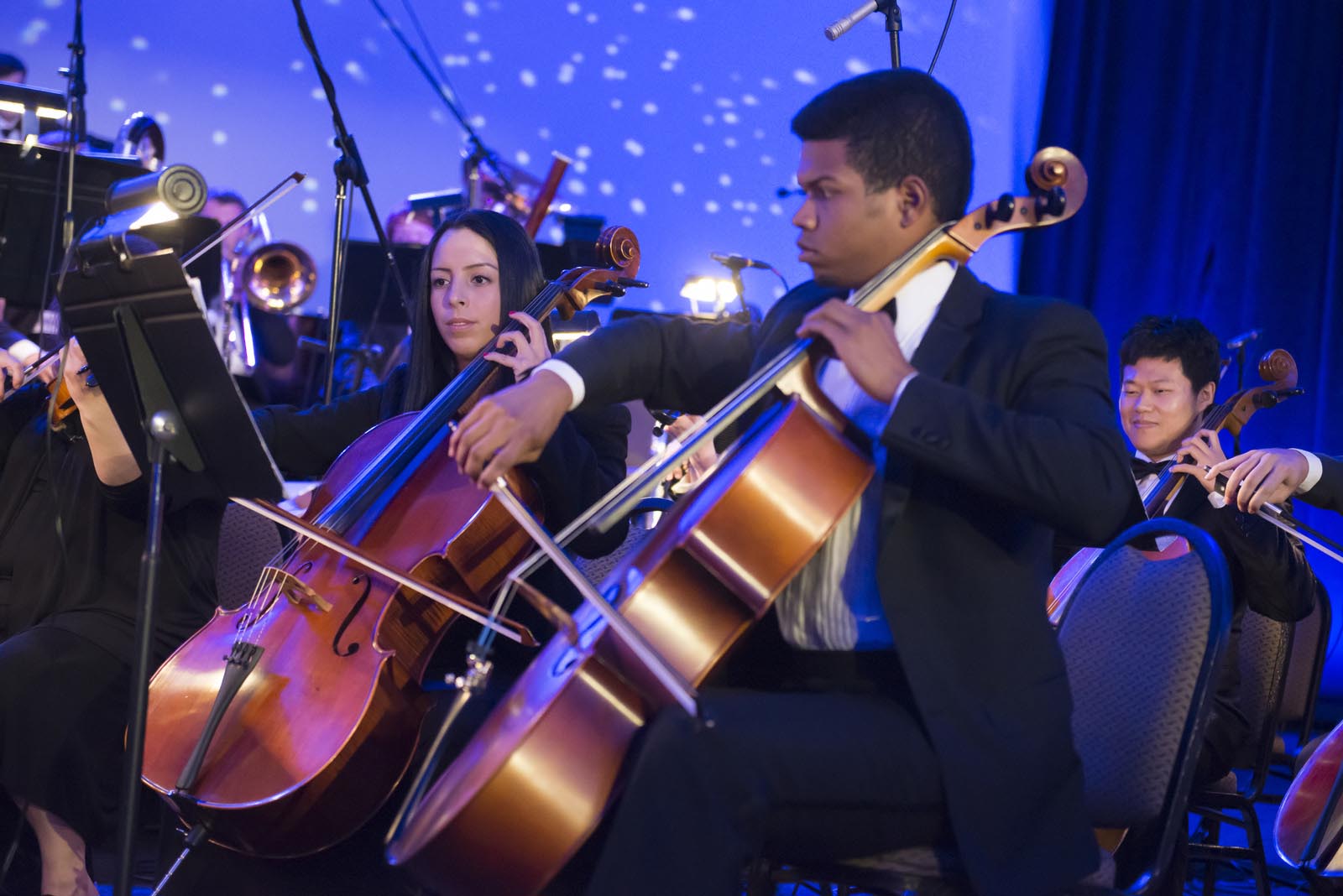 Student musicians play string instruments as part of an ensemble.