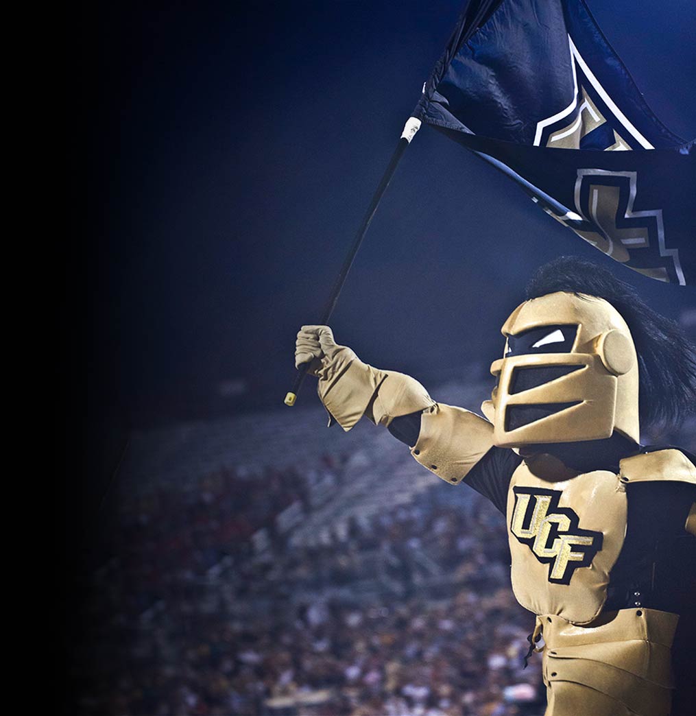 knightro holding the ucf flag before a ucf football game