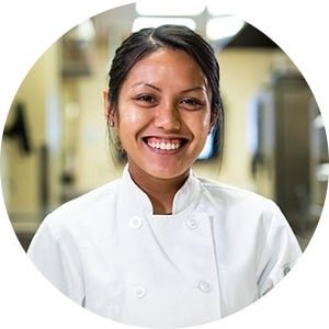Woman in culinary wearing white chef's jacket