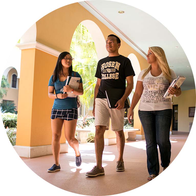 Rosen College students walking in outdoor hallway
