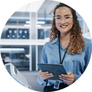 Smiling professional holding a tablet in a modern tech workspace.