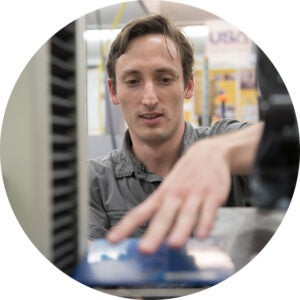 Engineer working hands-on with equipment in a lab setting.