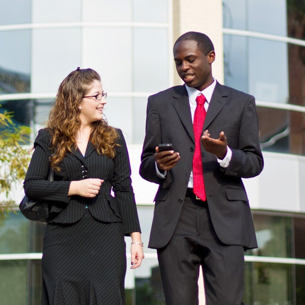 male and female professionals walking and talking outside of ucf building