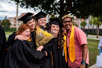 Five graduates from UCF's Inclusive Education Services taking a celebratory photo together after graduating