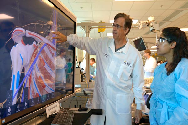 UCF College of Medicine Doctor teaches health sciences to female student using a digital display