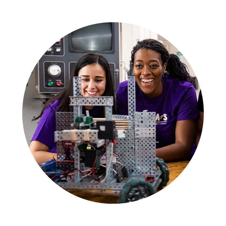 Female students working on engineering device. 