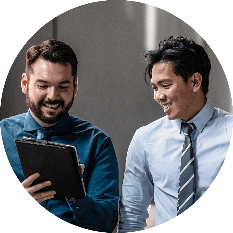 Two males working on a tablet.