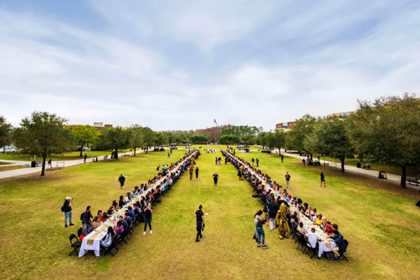 Students sitting at two long tables set up on Memory Mall during the Gather Luncheon