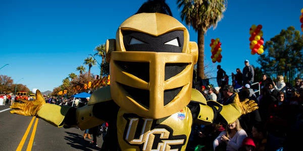 Knightro walking down a road surrounded by fans
