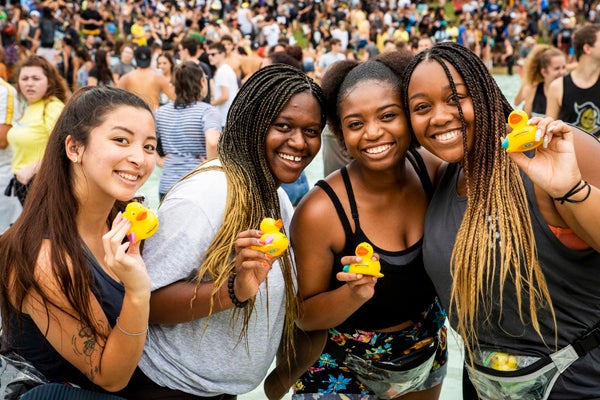 Female Students in the Reflecting Pond holding a duck during Spirit Splash