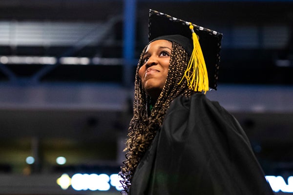 graduate walking across stage in official UCF regalia