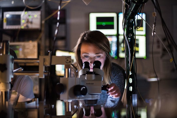 female looking into microscope