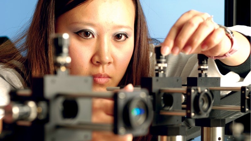 Woman adjusting photonics equipment