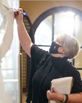 ucf hospitality faculty member writing on whiteboard