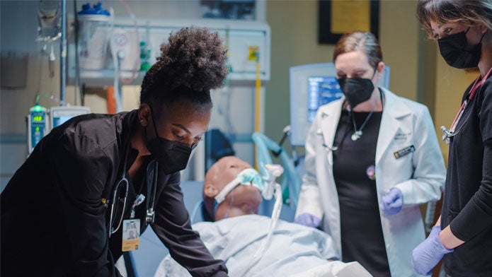 Student nurses work in a simulation experience