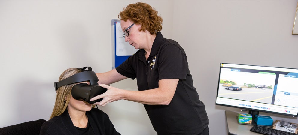 A researcher demonstrates exposure therapy using enhanced virtual reality (VR) technology at the UCF RESTORES facility