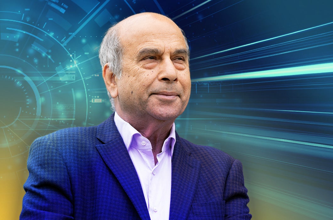 UCF Professor Mubarak Shah in front of a digital, futuristic background with blue and yellow tones.