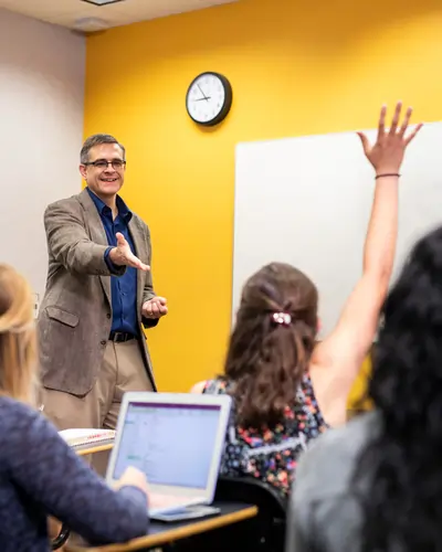 UCF professor engages a class as a student raises a hand.