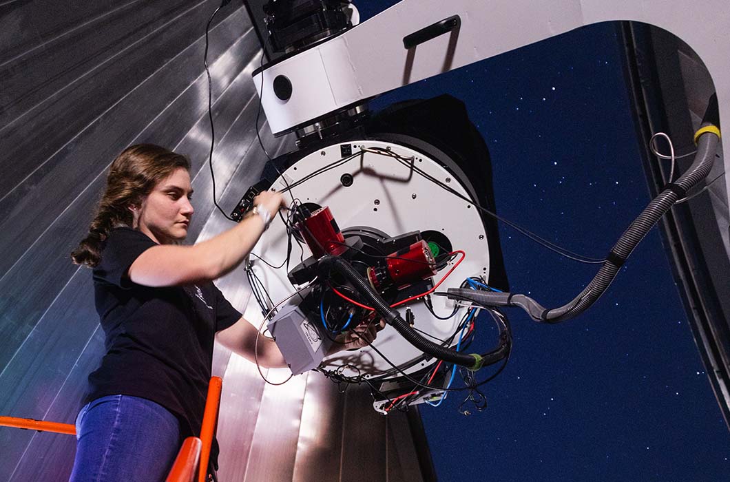 A UCF student works on a complex apparatus in Robinson Observatory on the main campus.