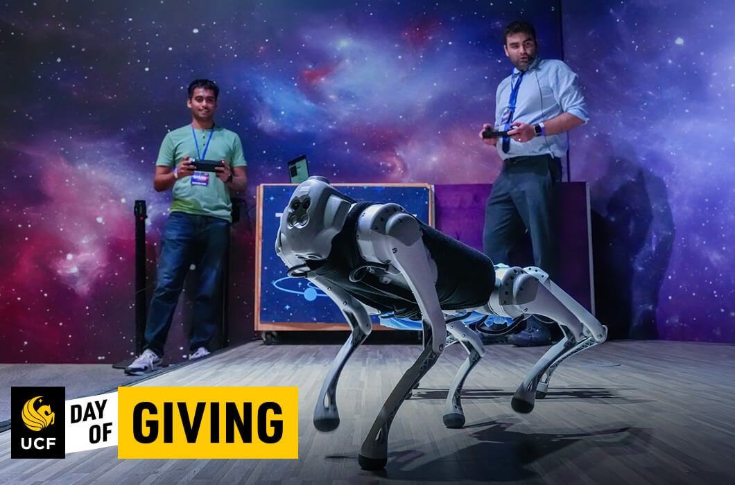 Two students controlling a robotic dog in front of a background of stars.