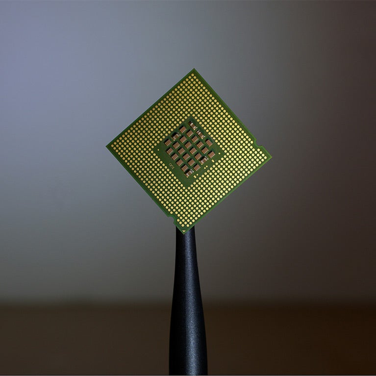 Close-up of a computer chip mounted upright against a blurred background.