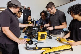 UCF Robotics Club students working with robot dog components