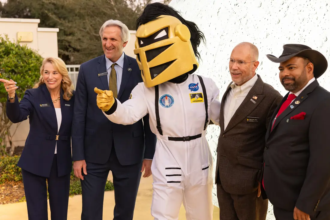 Tiffany Hughes, UCF College of Business; John Buckwalter, Provost; Greg Autry, Associate Provost for Space Commercialization; and Zaheer Ali, Program Director of Space Commercialization and Strategy pose outdoors with UCF mascot Knightro dressed as an astronaut.