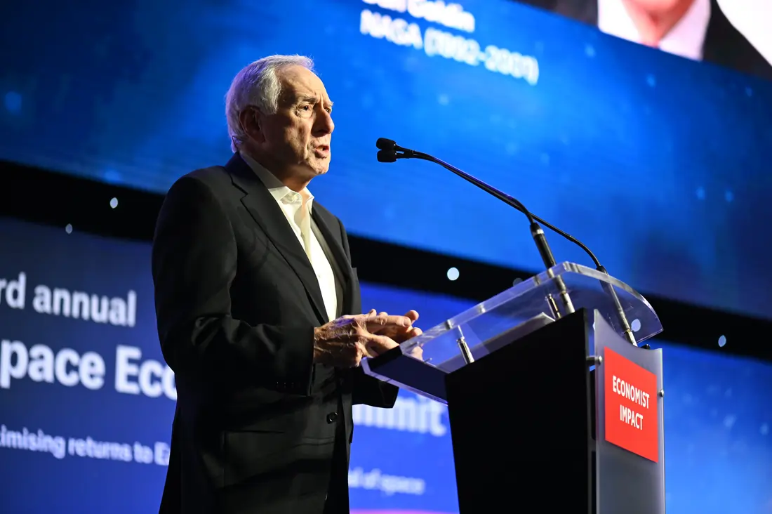 Dan Goldin speaking at a podium in front of a screen reading "3rd annual Space Economy Summit" at the Economist Space Economy Summit in 2025.