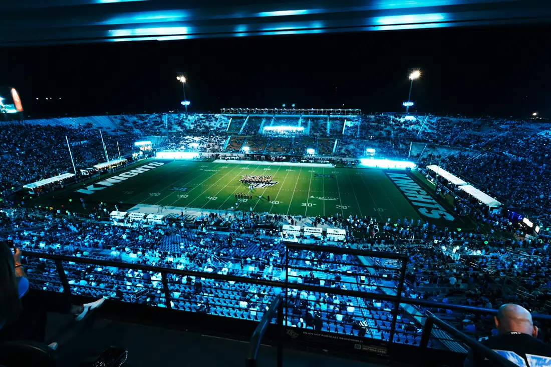Aerial view of a packed football stadium lit up at night.