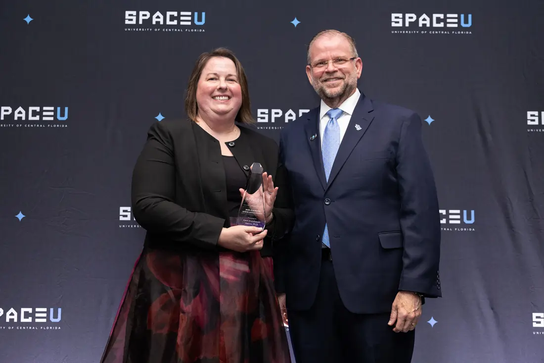 UCF President Alexander N. Cartwright presenting an award to planetary geologist and Associate Professor Kerri Donaldson-Hanna at the SpaceU Awards Dinner.