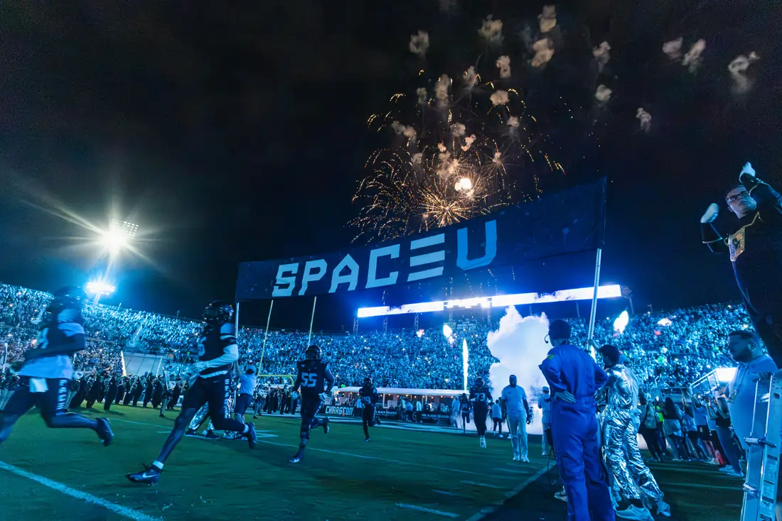 UCF football players on the field in custom uniforms nodding to hypersonic travel and space propulsion research, with fans filling the stands during the 2025 Space Game.