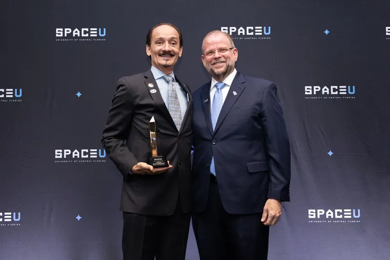 A SpaceU Awards Dinner honoree stands with a UCF leader.