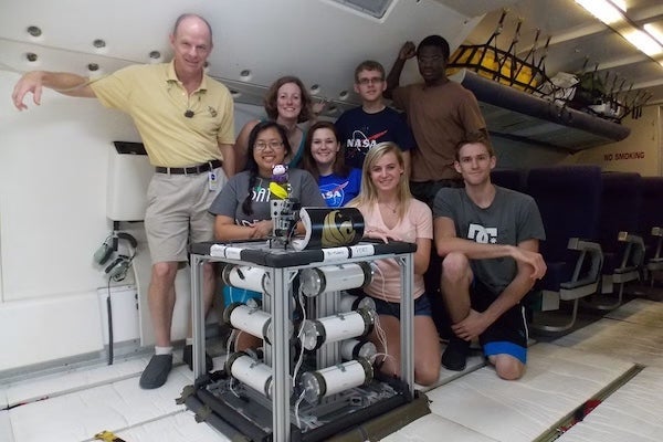 Professor Joshua Colwell, Associate Professor Adrienne Dove and a group of students aboard a zero-gravity flight with an experiment built in UCF’s microgravity center.