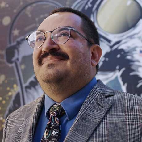 Emmanuel Urquieta standing in front of a SpaceU sign