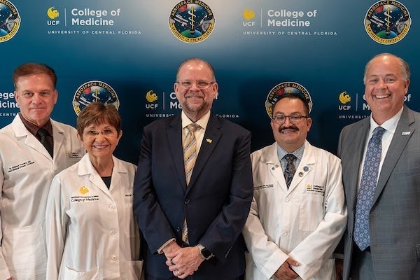 William “Ed” Powers, chief medical officer of UCF’s Center for Aerospace and Extreme Environments Medicine; Deborah German, founding dean of the UCF College of Medicine and vice president for health affairs; UCF President Alexander N. Cartwright; Emmanuel Urquieta, vice chair for aerospace medicine at the UCF College of Medicine; and Ted Kitchens, COO of the Greater Orlando Aviation Authority, celebrate the opening of the University of Central Florida Aerospace Medicine Clinic.