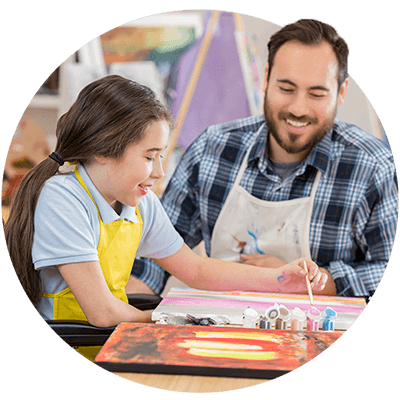 Art teacher supporting girl in wheelchair