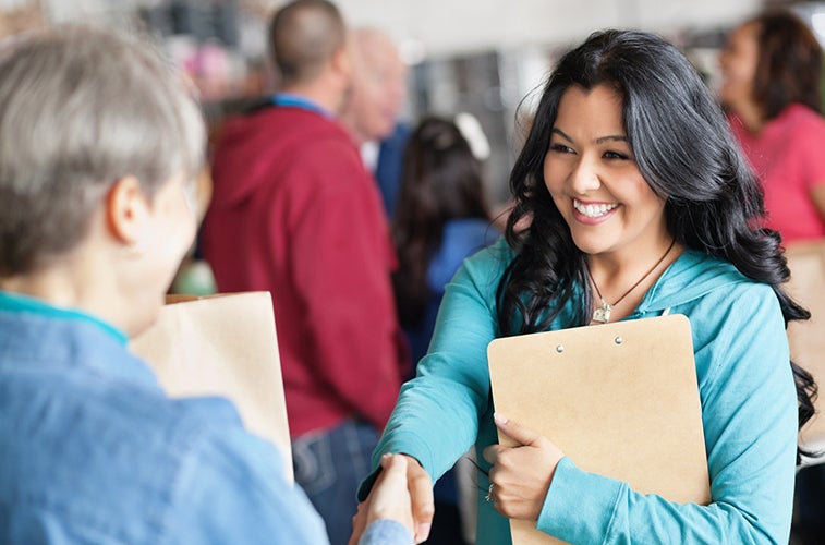 Female volunteer greeting woman at donation facility