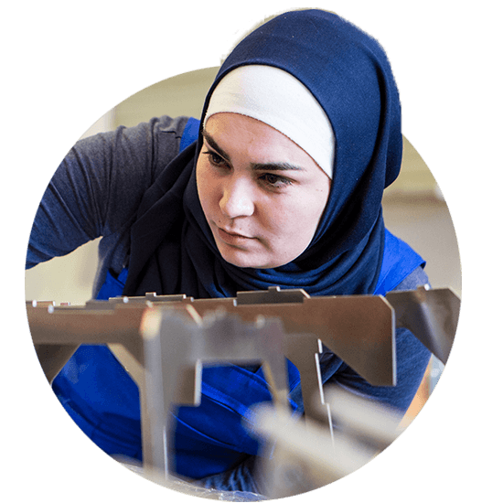 Woman with headscarf looking at metal.