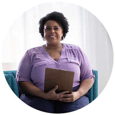 Behavior Analysts sits smiling at the camera.