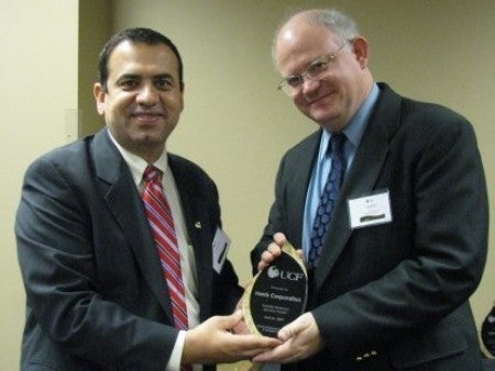 Issa Batarseh, Director of the School of EECS presents award to Mr. Craig Miller, VP of Research, Harris Corp.