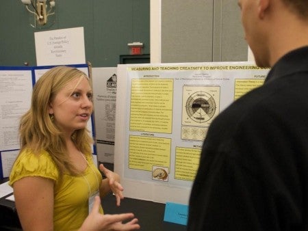 Showcase participant Lauren Cavette explains her research to attendees.