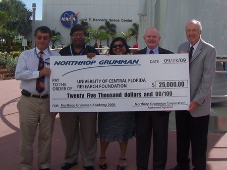 Participating in the check presentation at the Kennedy Space Center Visitor Complex Rocket Garden are, from left: Robert Crabbs, associate director of UCF's Florida Space Institute; Jaydeep Mukherjee, director, NASA Florida Space Grant Consortium, and interim director, Florida Space Institute; Sreela Mallick, assistant director, NASA Florida Space Grant Consortium; Roy D. Bridges, Jr., director, Space and Science Services, Northrop Grumman Technical Services, and Roy Tharpe, Space Gateway Support deputy chief of operations at Northrop Grumman and chairman of the National Space Club Florida Committee.