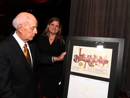 Founding president Charles Millican looks at the plaque noting that a star in the Pegasus Constellation was named in first lady Frances H. Millican's honor. Darla Olive of the Alumni Association stands behind him.