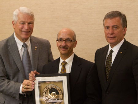 Conrad Santiago (center) was awarded emeritus status by the Board of Trustees on Thursday. He is shown here with UCF President John Hitt (left) and Board of Trustees Chair Rick Walsh